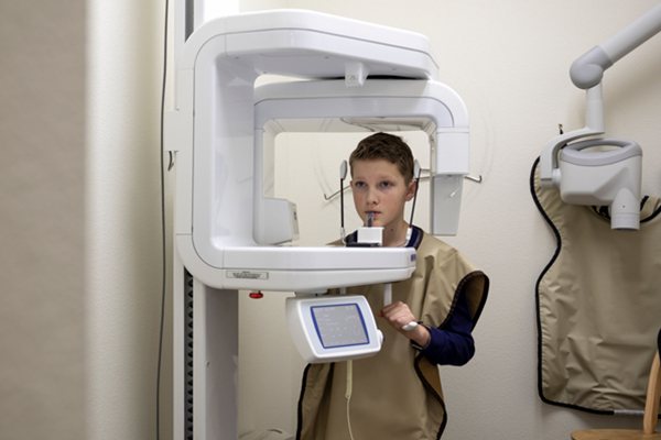 Person undergoing dental X-ray with protective apron.