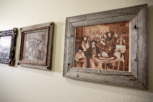 Vintage photos in rustic wooden frames on wall.