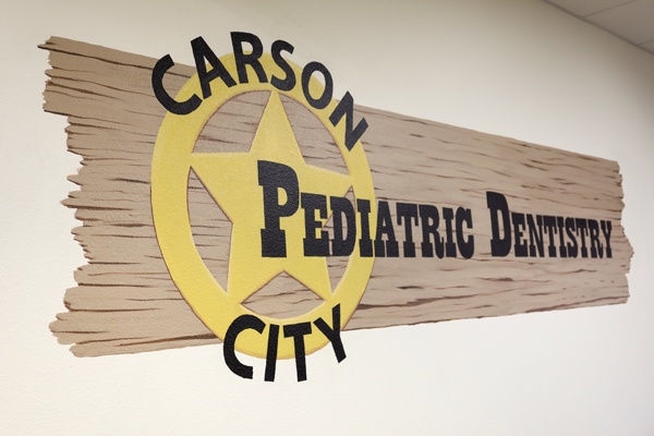 Carson City Pediatric Dentistry logo on wood sign.