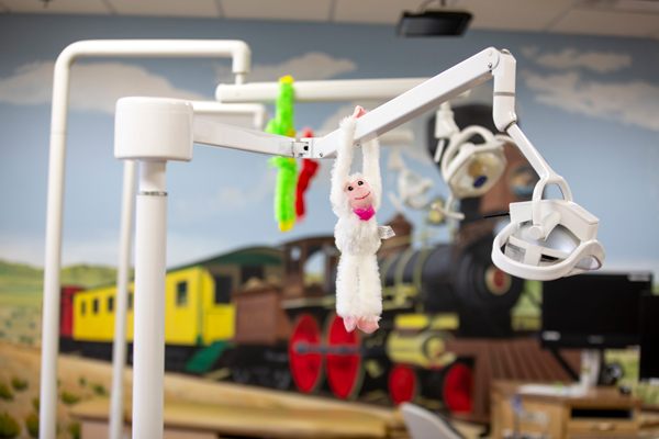 Dental equipment in children's office with train mural.