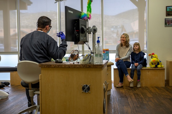 Dentist consults mother and child in office.