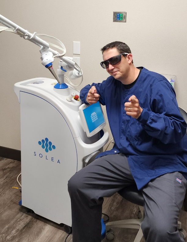 Person with Solea dental laser machine in office.