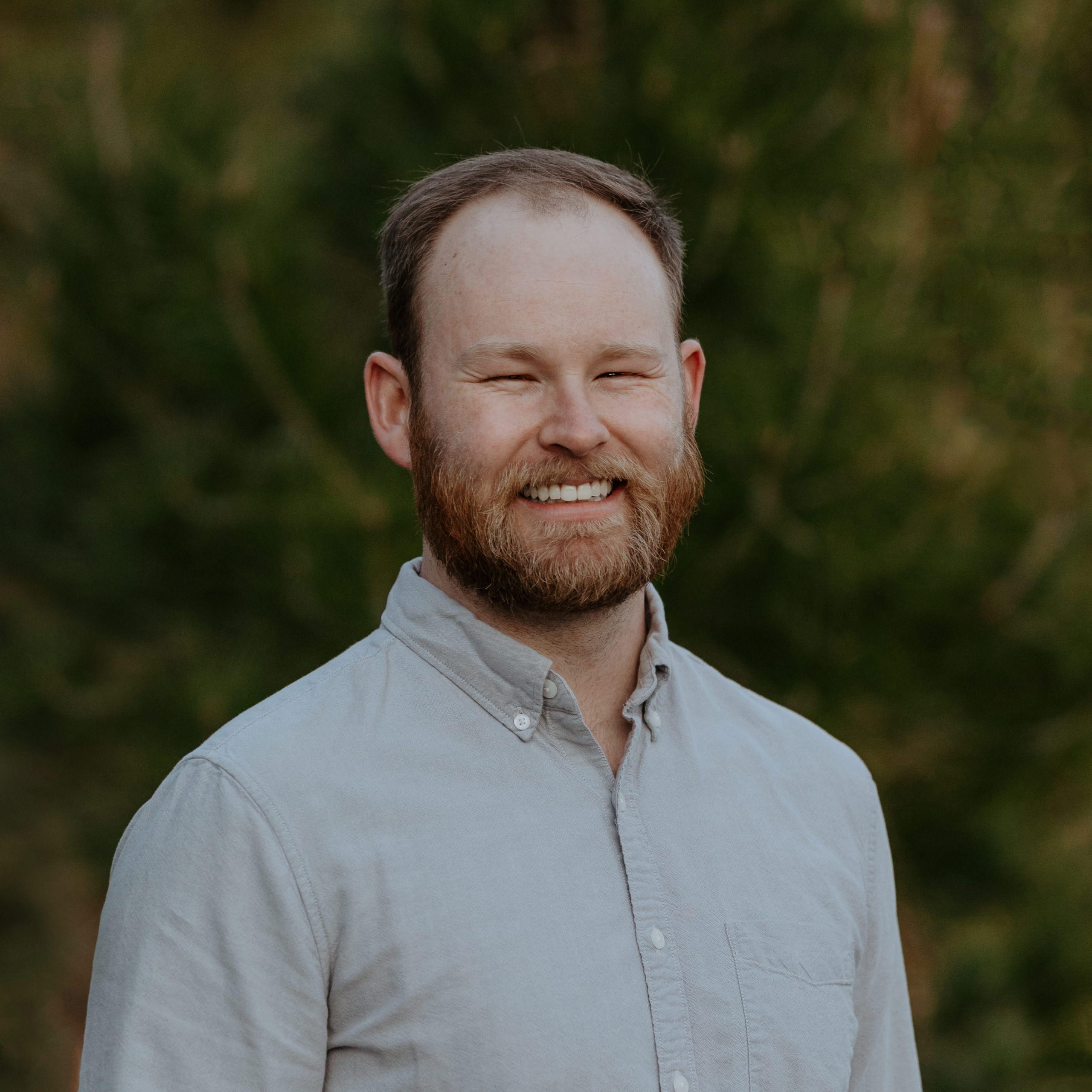 Smiling man in a light shirt outdoors